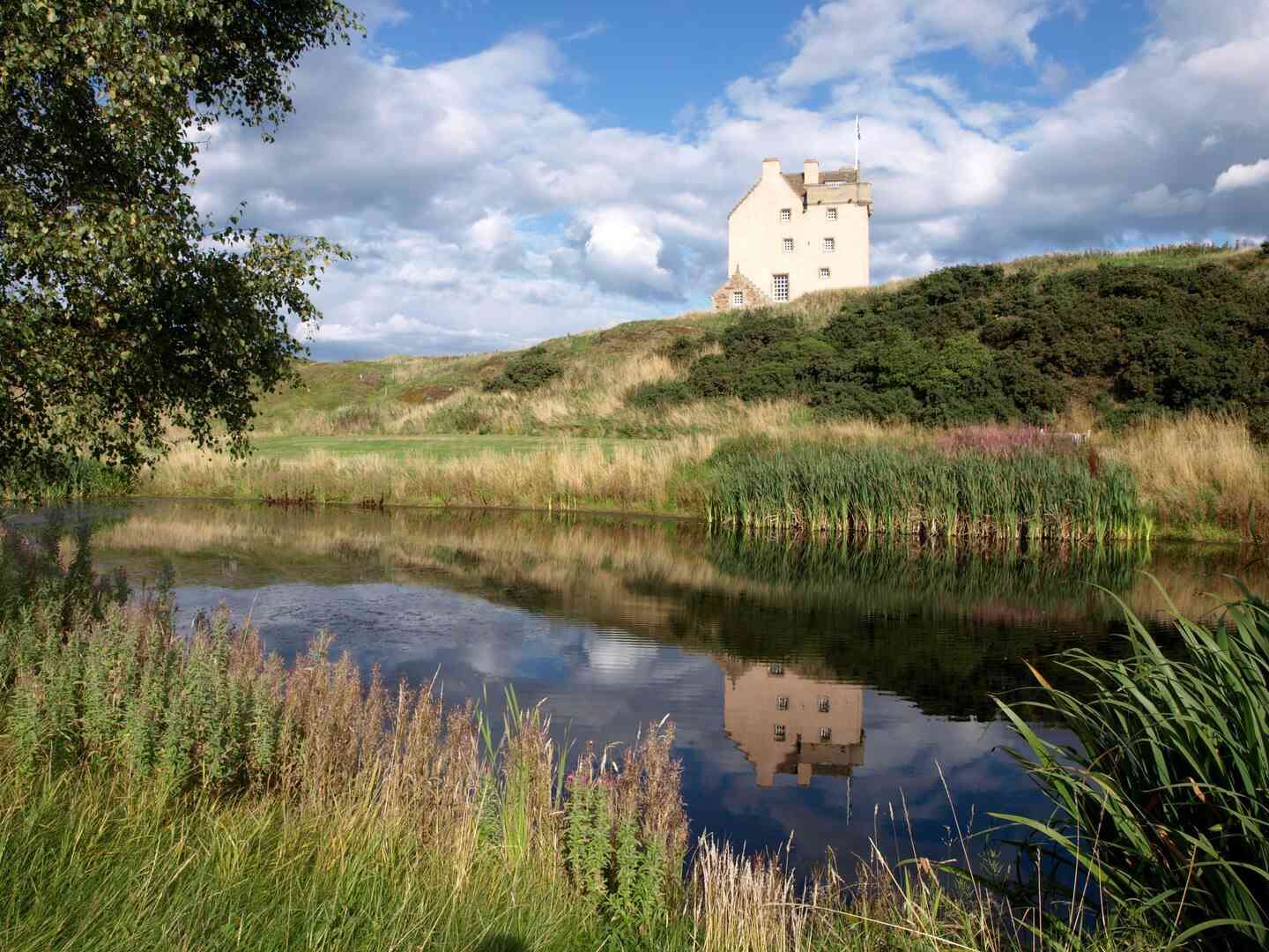 Lush landscape and river in front of an Airbnb castle wedding venue in the U.K.