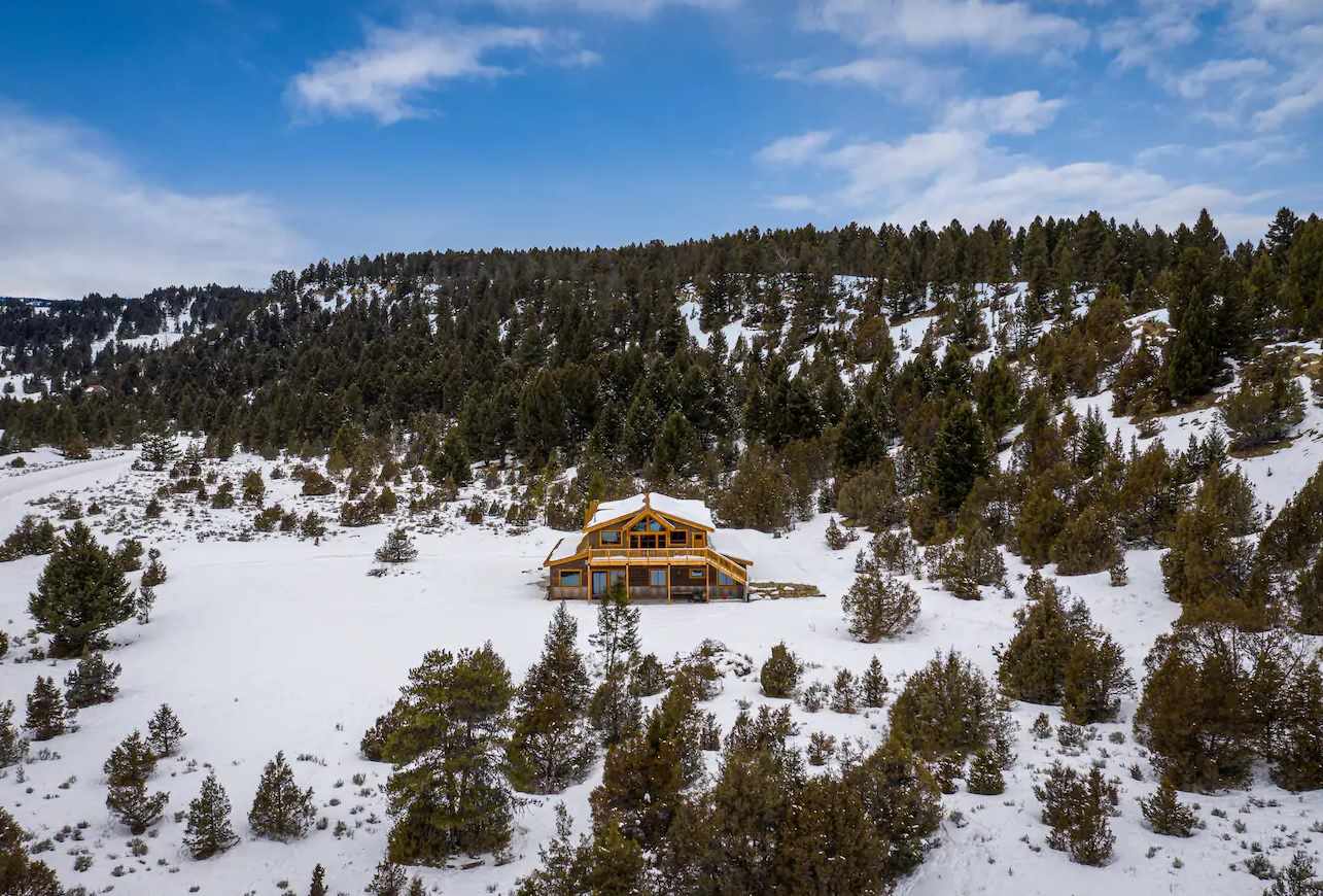 Wooden cabin Airbnb wedding venue surrounded by snow and forrest in Montana.