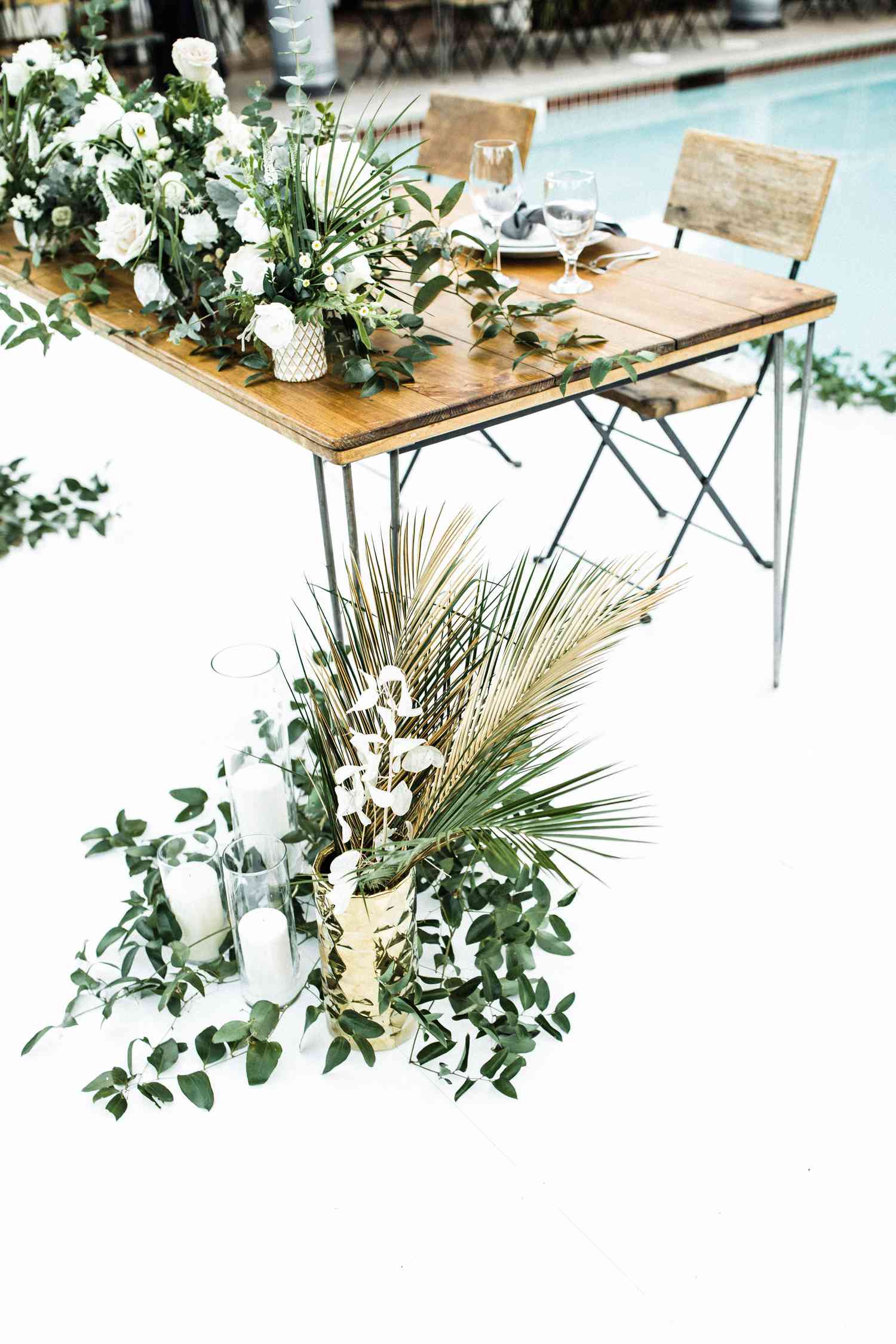 Bare wooden sweetheart table with white and green centerpiece and ends