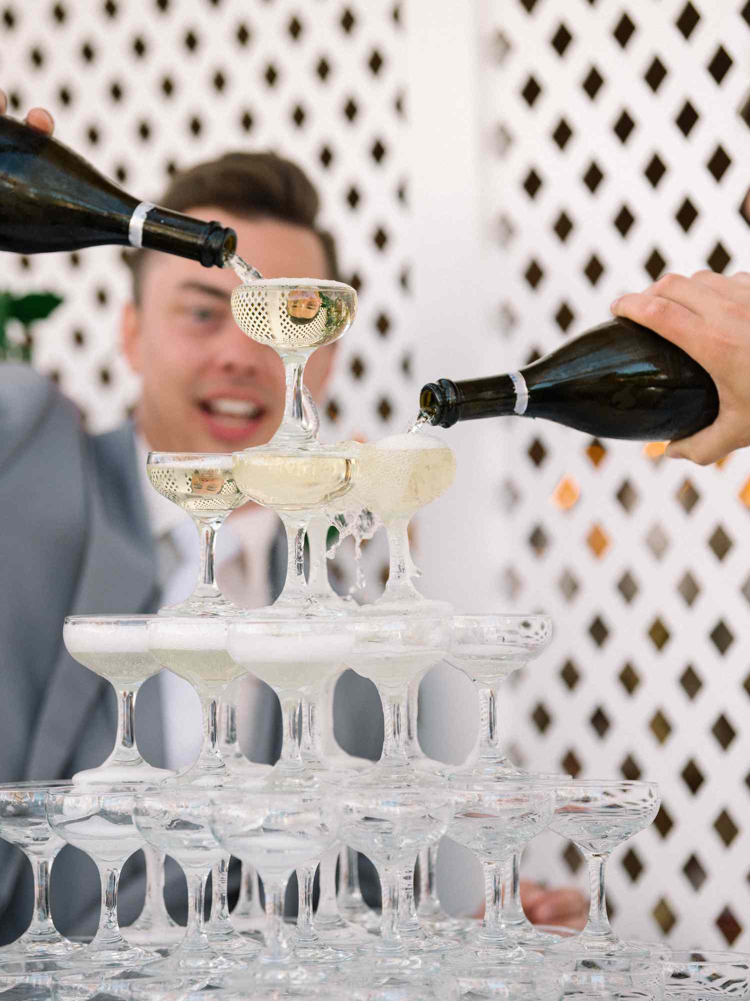 Two Grooms Pour Champagne Down a Tower of Coupes During Their Wedding Entrance