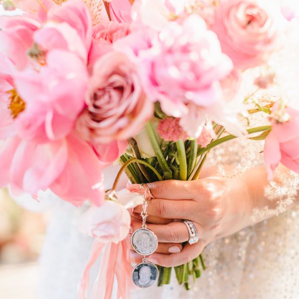Bride holding a wedding bouquet of pink flowers with charms