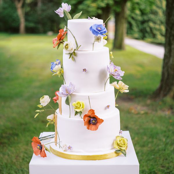 white wedding cake with multicolored sugar flowers