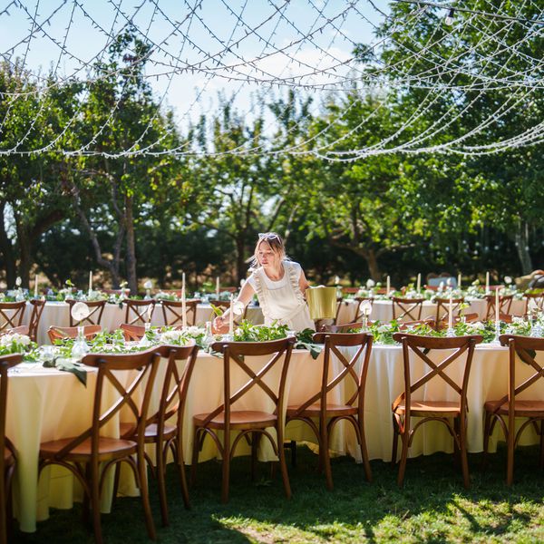 Wedding Coordinator Makes Last-Minute Adjustments to Table at Reception Venue