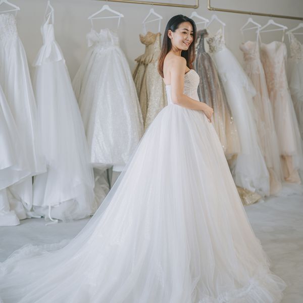 bride portrait posing looking at camera smiling at bridal shop trying on wedding dress grown