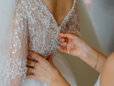 Close up back of a bride dress getting dressed