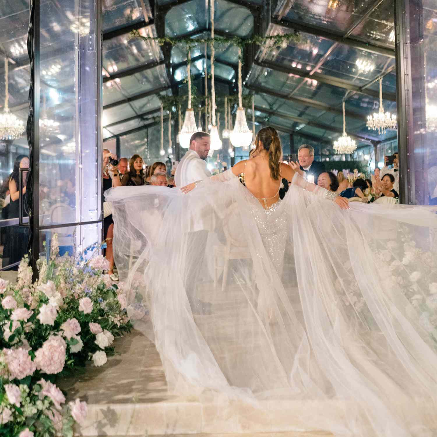 Bride and Groom During Their Wedding Entrance With Bride Spreading Her Tulle Sleeves