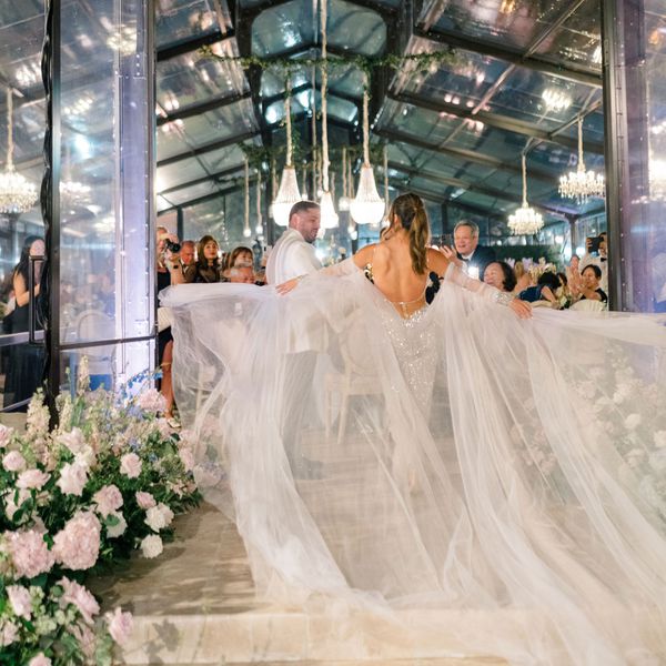 Bride and Groom During Their Wedding Entrance With Bride Spreading Her Tulle Sleeves