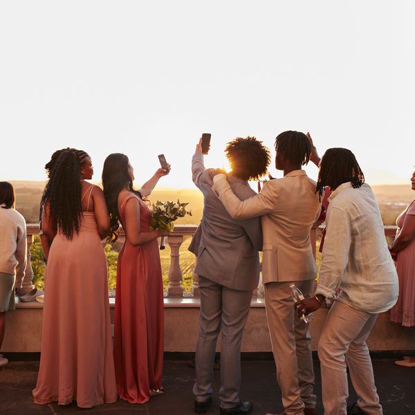 Wedding Guests Taking Selfies on Balcony During Sunset