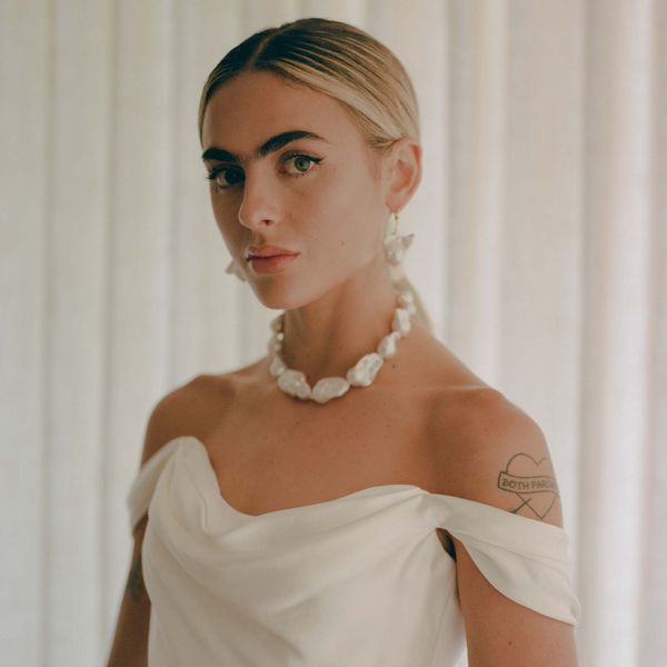 close up portrait of bride wearing a pearl necklace, pearl earrings, and an off-the-shoulder wedding gown