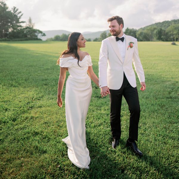 bride and groom holding hands in an open field