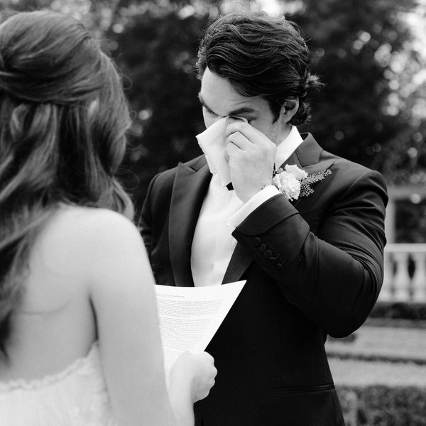Groom in Black Tuxedo Wiping Tears While Listening to Vows From Bride