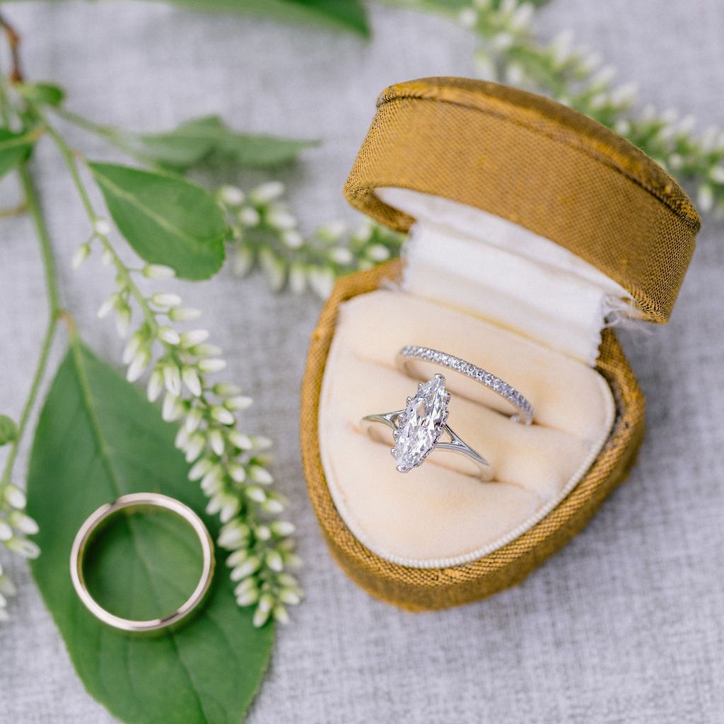Diamond Engagement Ring With Silver Band and Diamond Wedding Band in Ring Box With Gold Wedding Band on Leaf