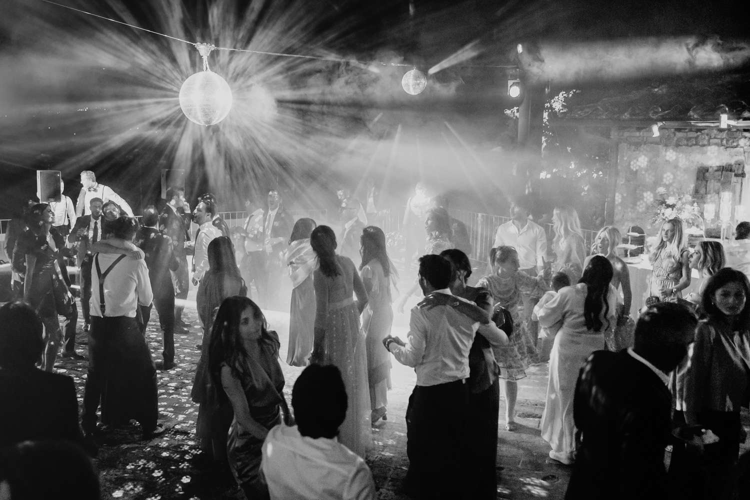 Wedding Guests on Dance Floor Beneath Disco Lights at Ceremony in Tuscany