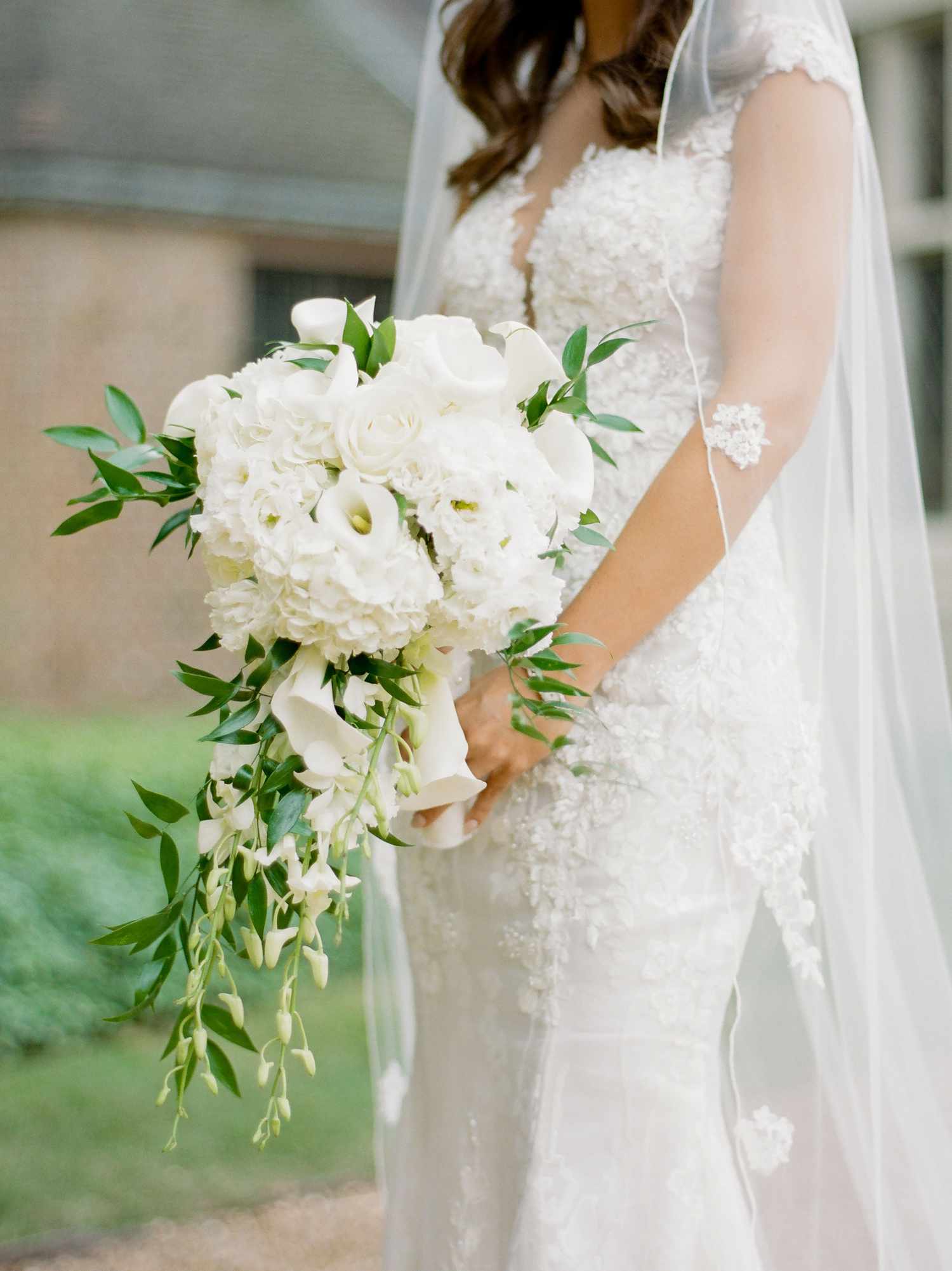 Bride Holding White Bouquet With Hydrangeas, Roses, Orchids, and Myrtle
