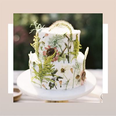 Two-tiered white wedding cake decorated with real flowers