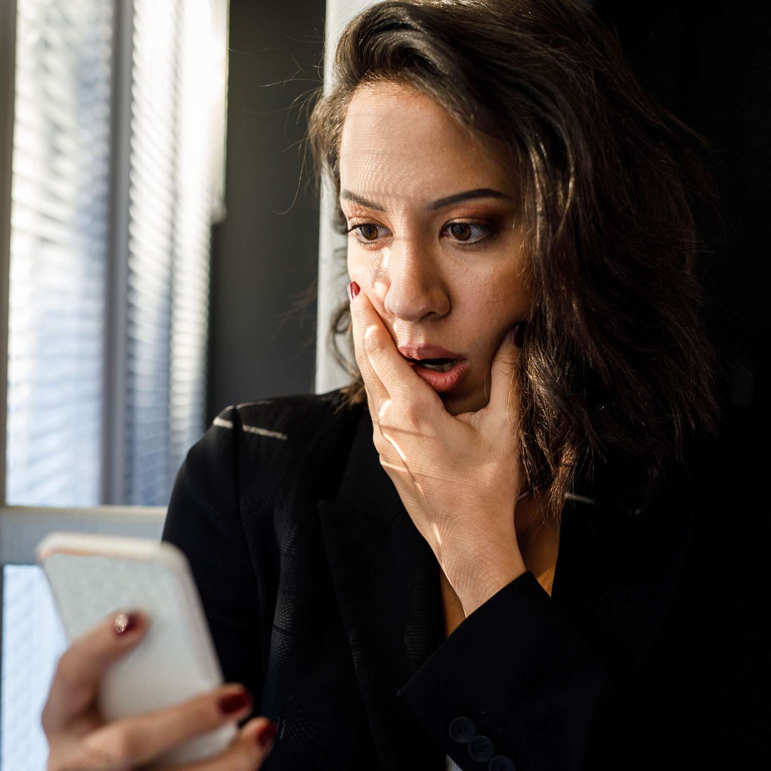 Woman Looks Horrified as She Reads Text Message on Her Phone