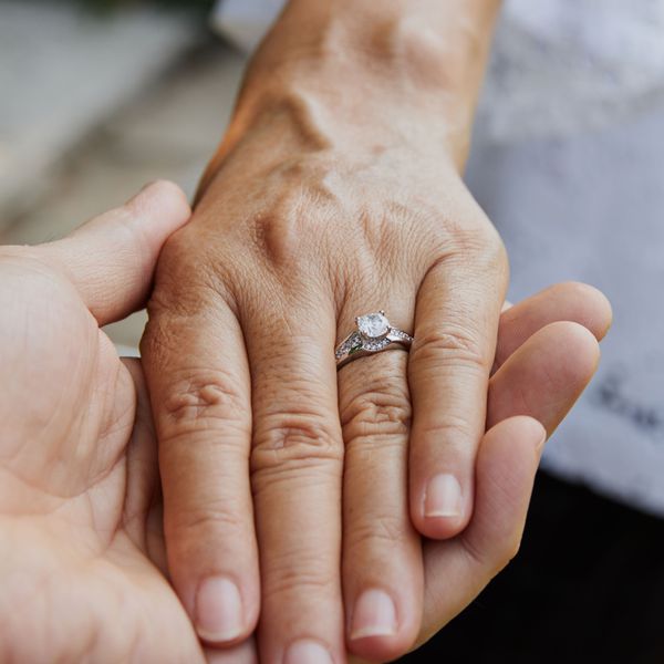 Man Holds Woman's Hand as She Models Engagement Ring