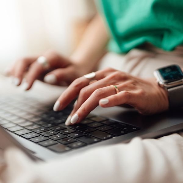 Woman Designs Her Electronic Save-the-Dates While Typing on a Laptop