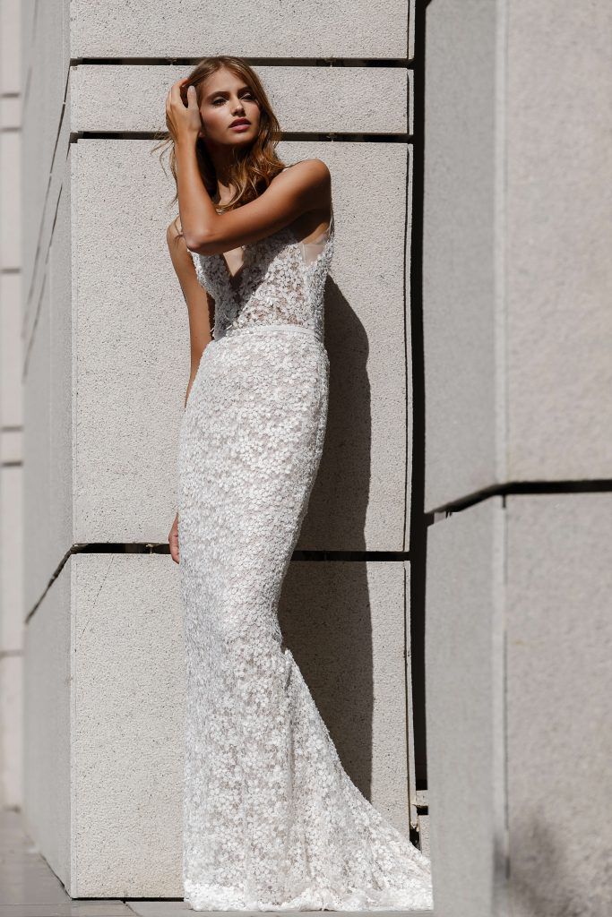 Model in fitted low-cut lace bridal gown