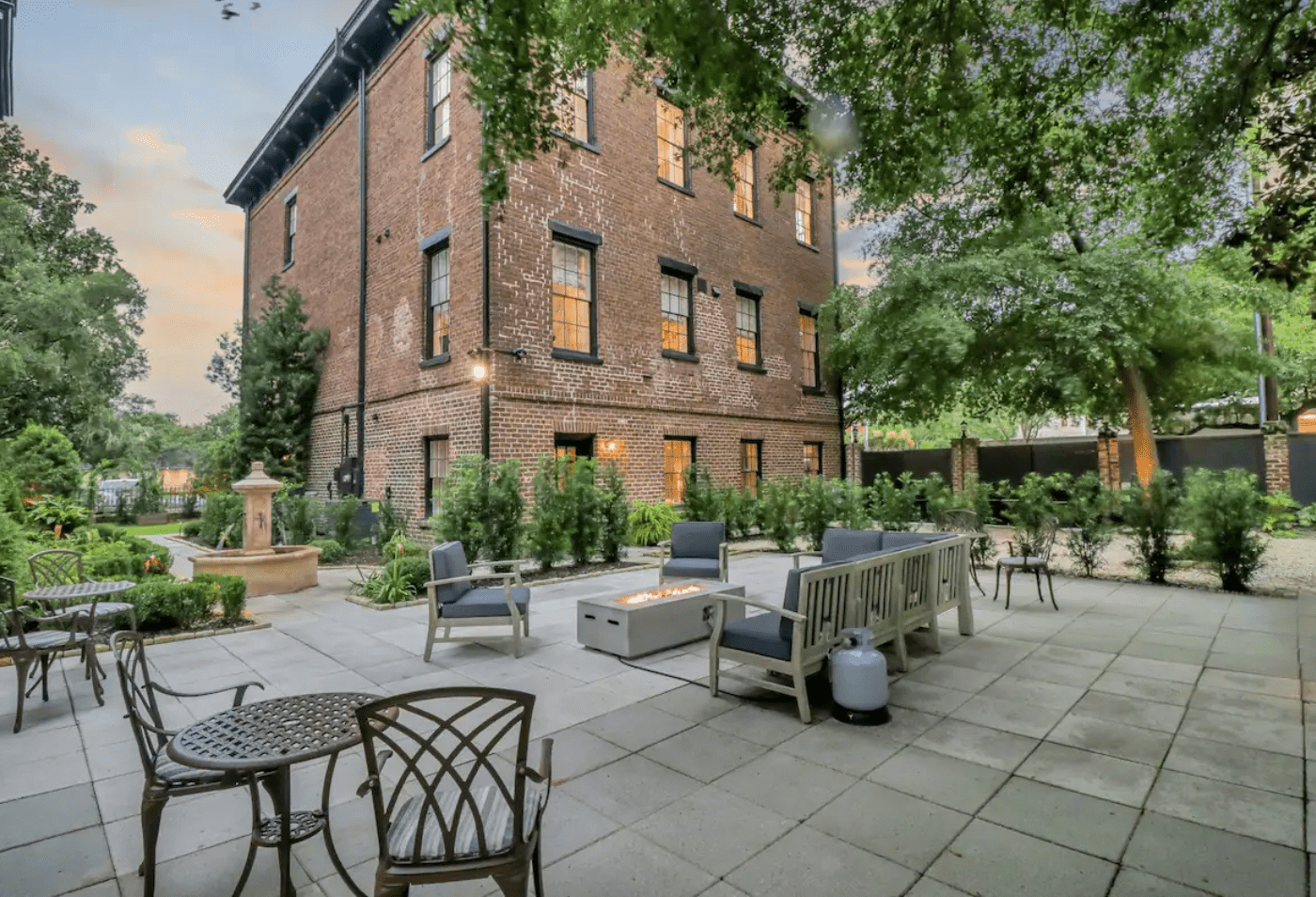 Courtyard with furniture and fire pit in backyard of brick estate