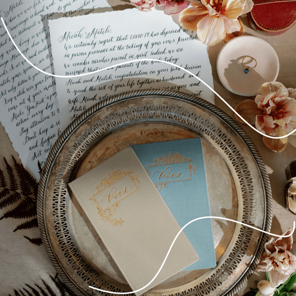 ceremony script in cursive on deckled edge paper with peach flowers, ring, and vow cards on silver charger,