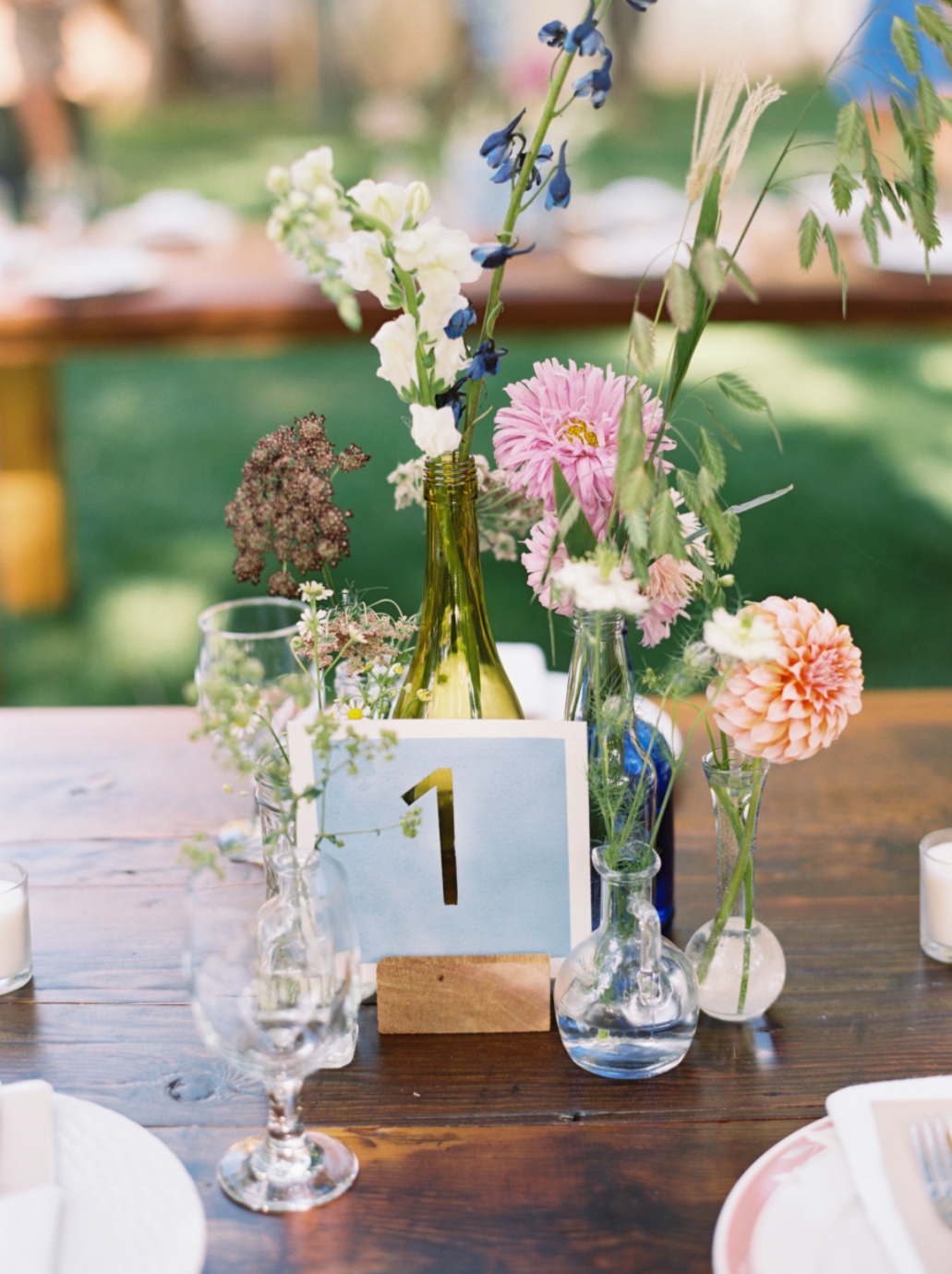 Floral arrangement of single booms in eclectic bud vases grouped together