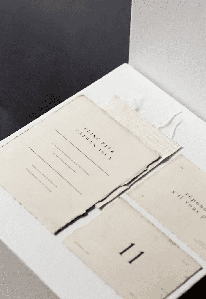 A tea-stained deckle-edge wedding invitation suite.