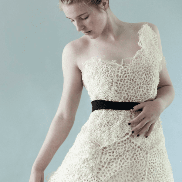 Biodegradable wedding dress with asymmetrical neckline and black belt