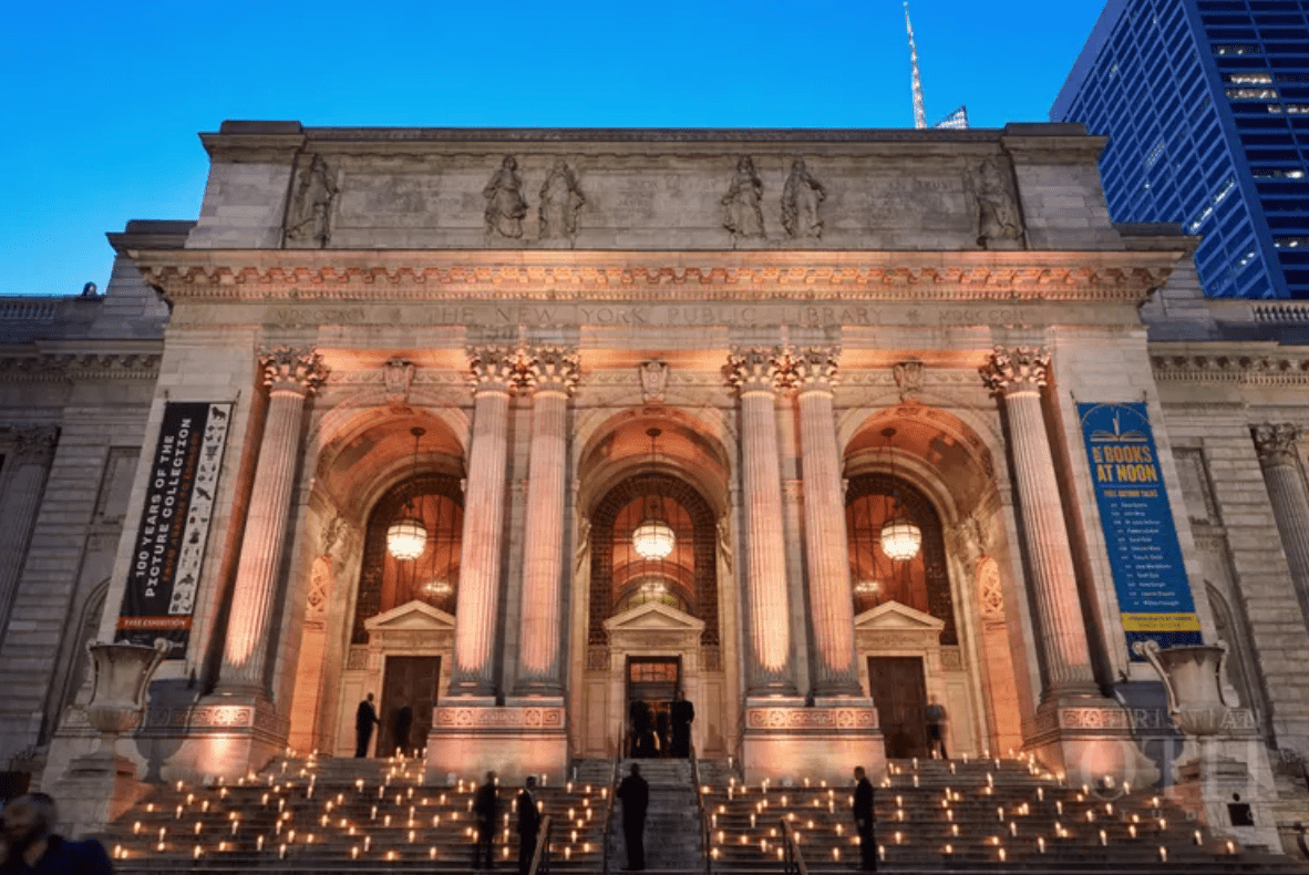 Exterior view at night of lit candles on the stone steps of New York Public Library, a wedding venue in NYC.